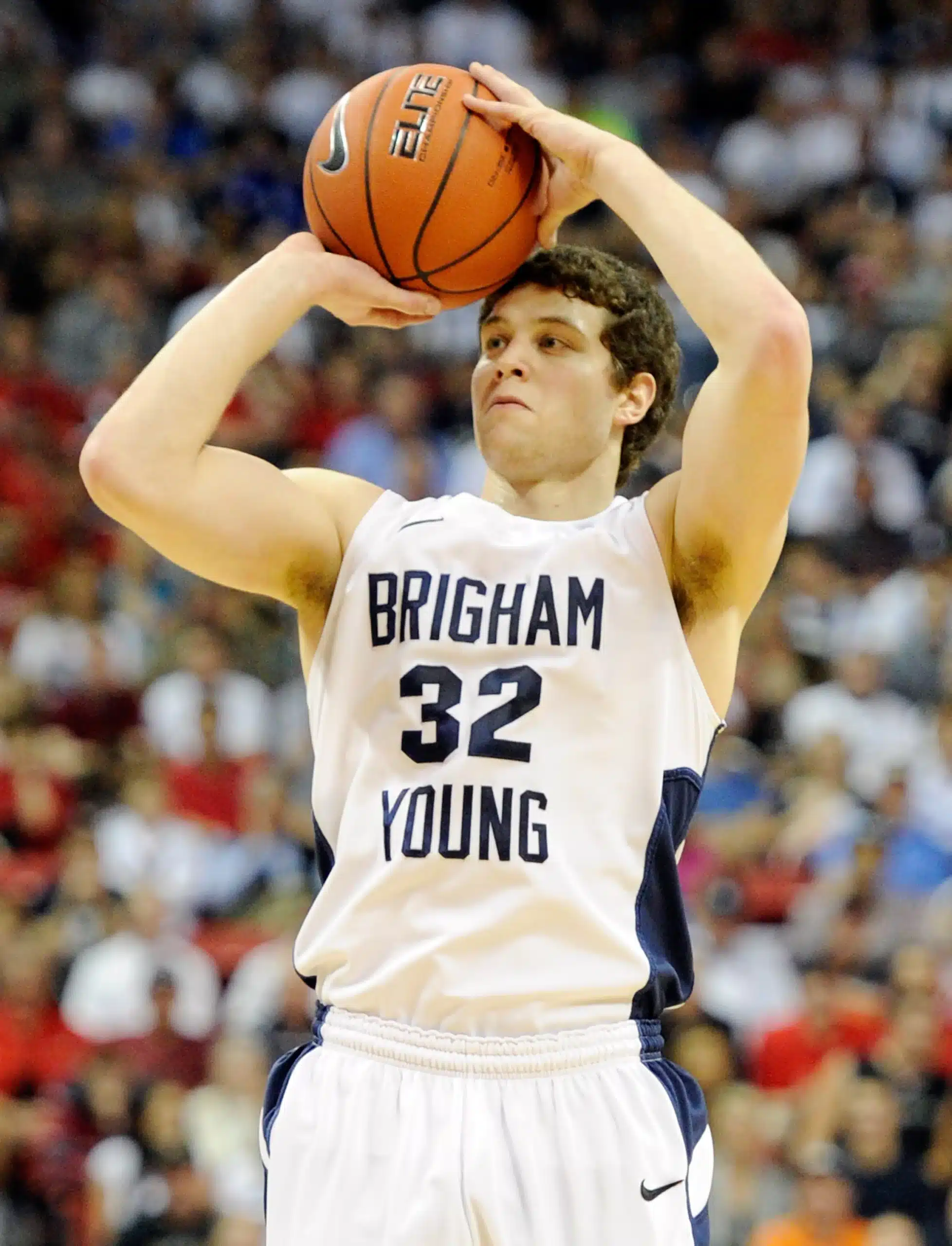 ncaam scores - A young man in a white uniform shooting a basketball ball