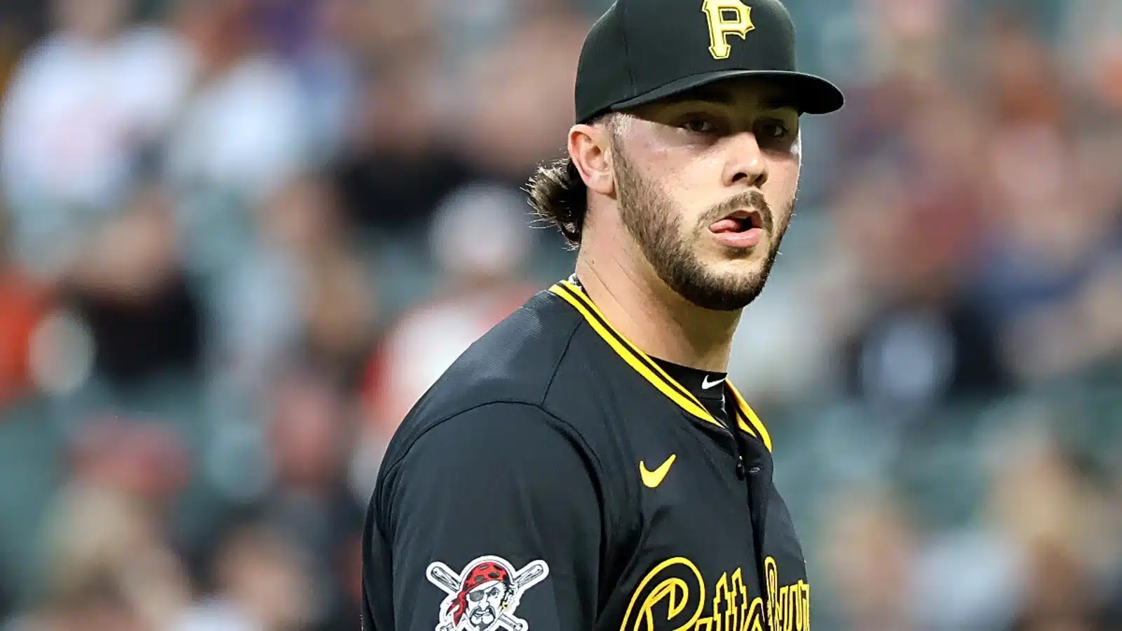 A baseball Pittsburgh Pirates vs Mets live stream in a black uniform and a yellow hat
