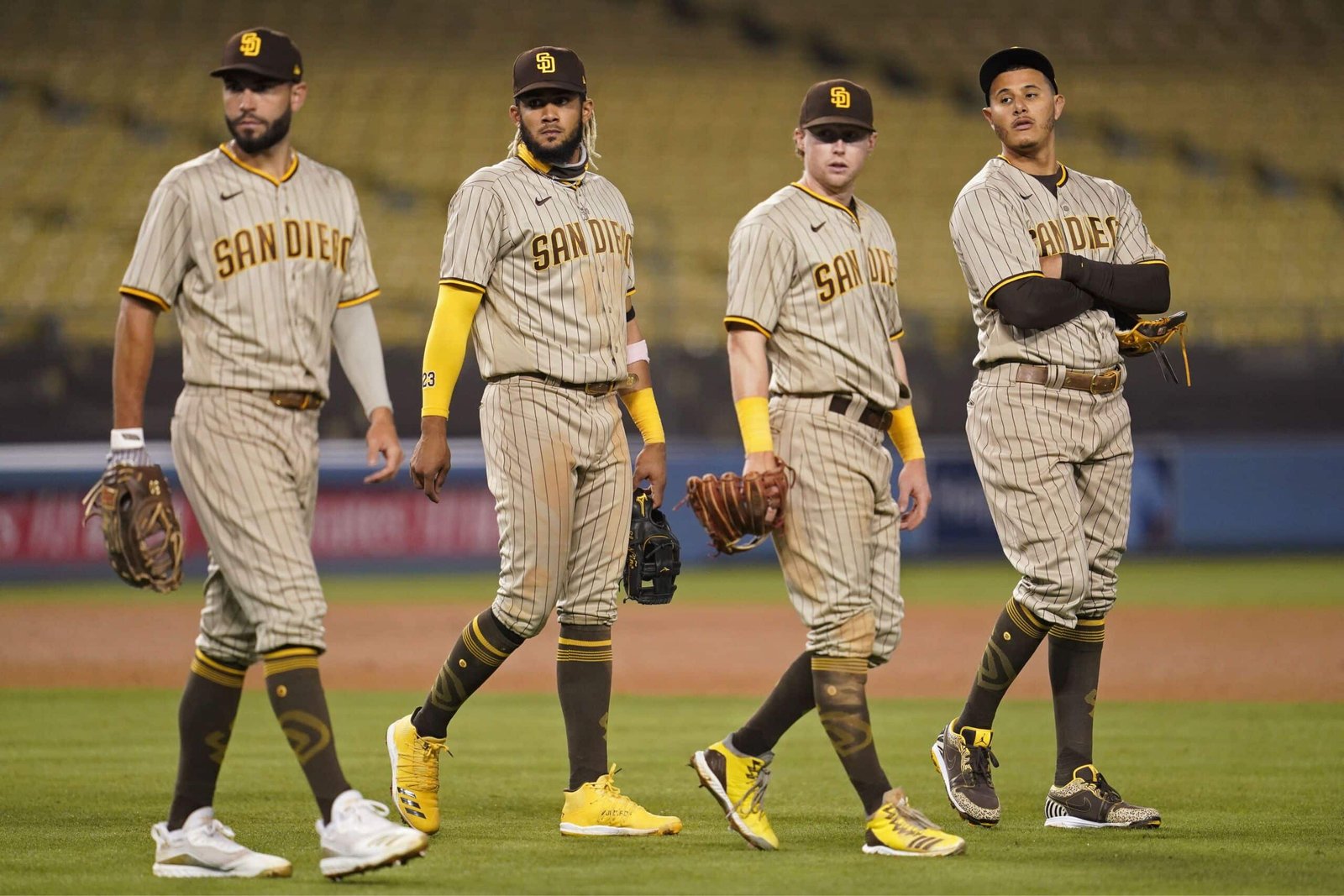 Three baseball san diego padres vs boston red soxs walking on a field